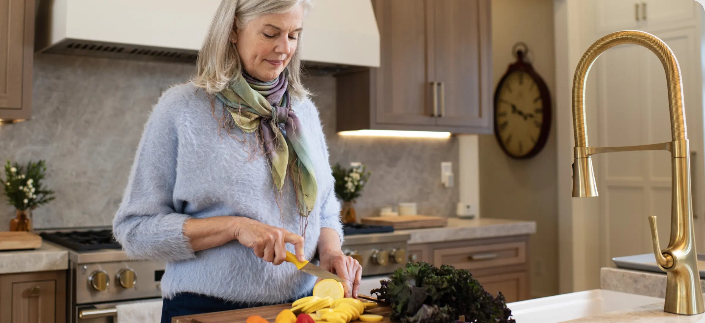 An older woman slices vegetables at her kitchen counter