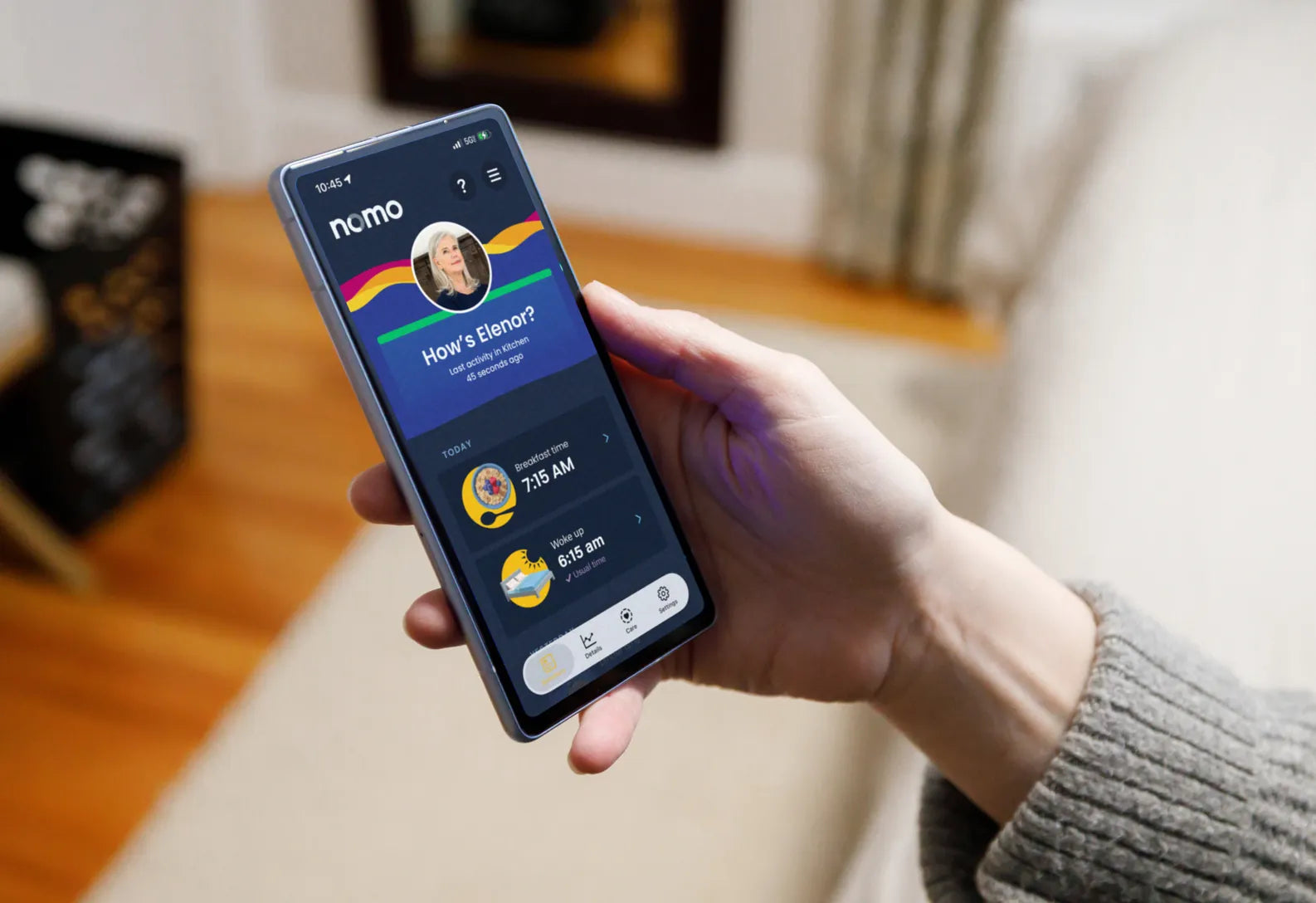 A hand holding a phone open to the Nomo app, showing how Eleanor's morning is going