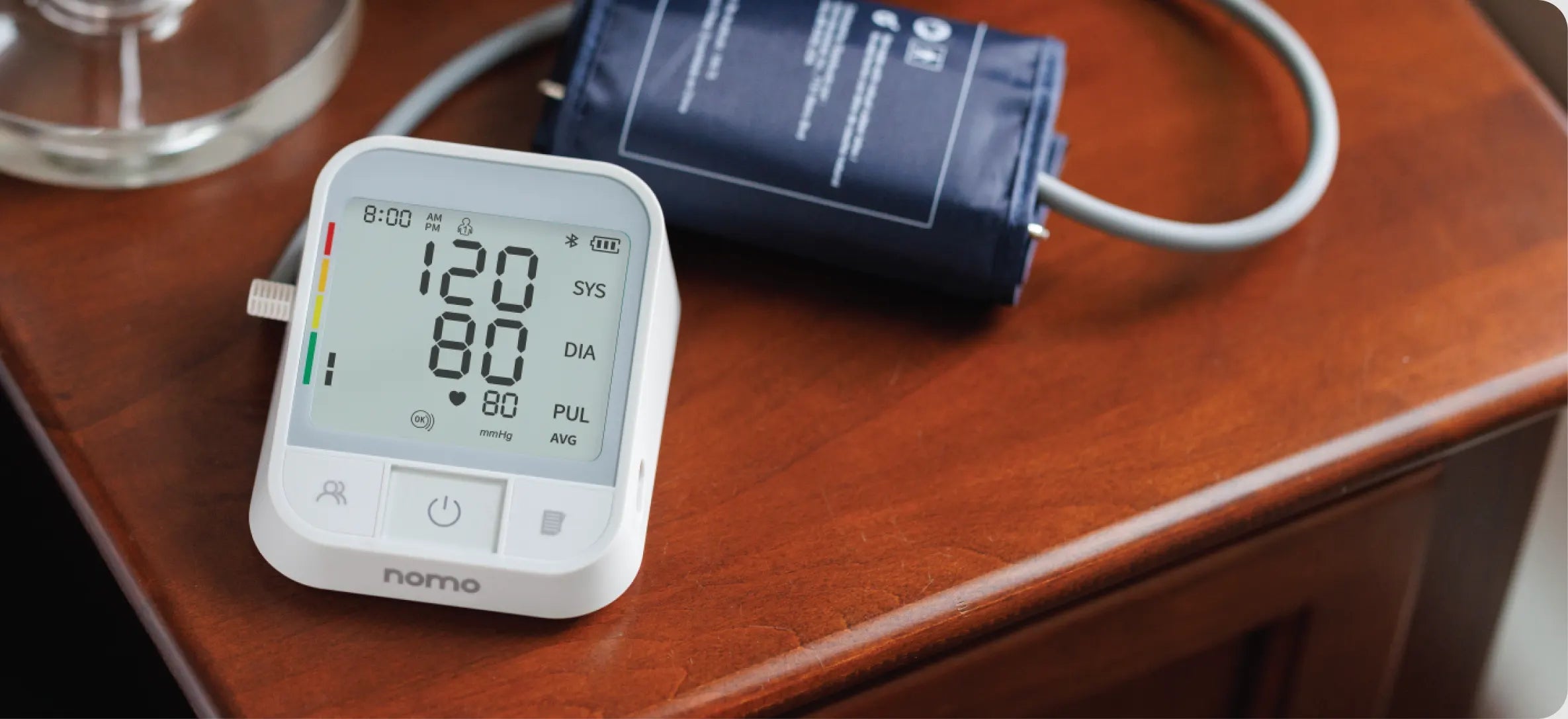 A Nomo blood pressure monitor showing a reading of 120 over 80