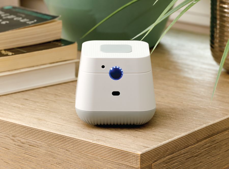 The Nomo Hub on a wooden side table next to a stack of books